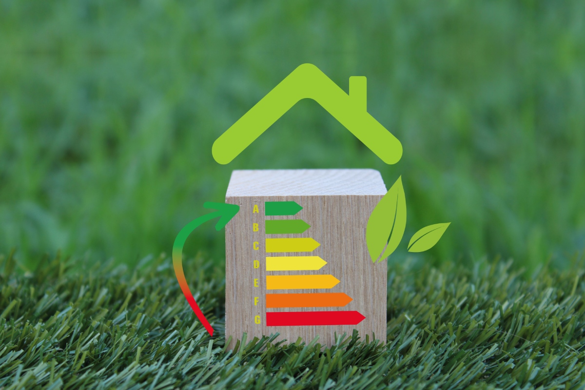 Étiquette DPE de classe A à G sur cube en bois posé sur l'herbe